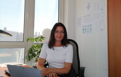 Eine junge Frau sitzt in ihrem Büro am Schreibtisch.