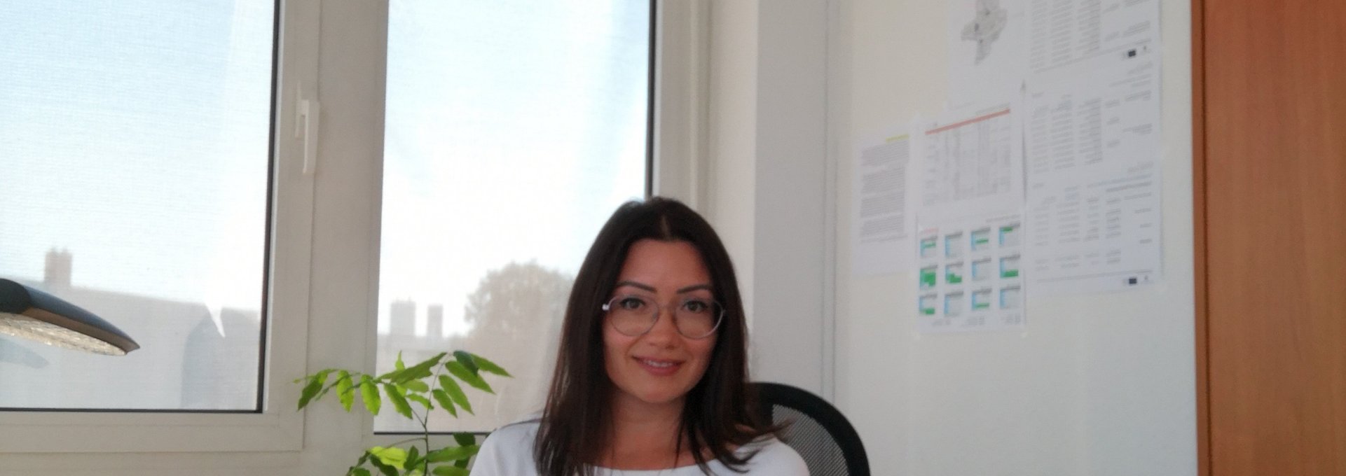 Eine junge Frau sitzt in ihrem Büro am Schreibtisch.