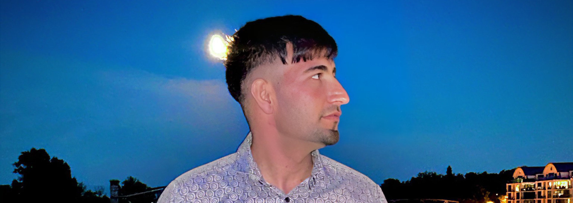 Ein junge Mann steht nachts draußen