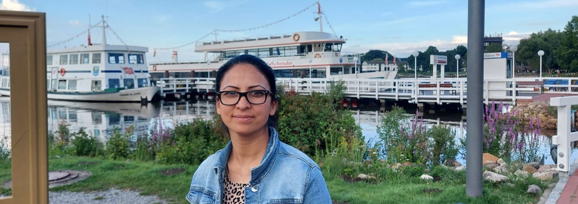Eine junge Frau steh in einem Hafen.