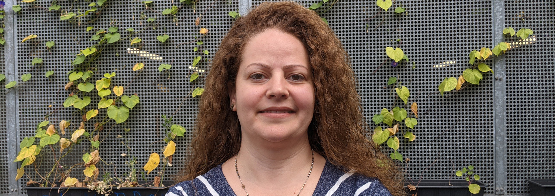 Eine Frau mit roten Haaren steht vor der Kamera.