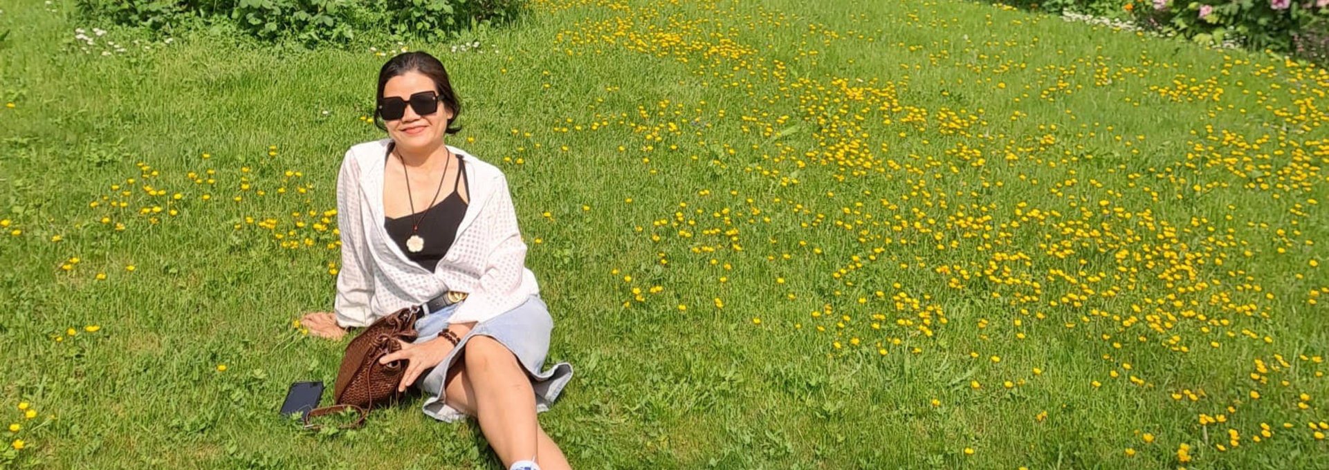 Eine Frau sitzt auf einer Wiese