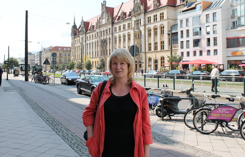 Eine junge Frau steht auf der Straße in Magdeburg.