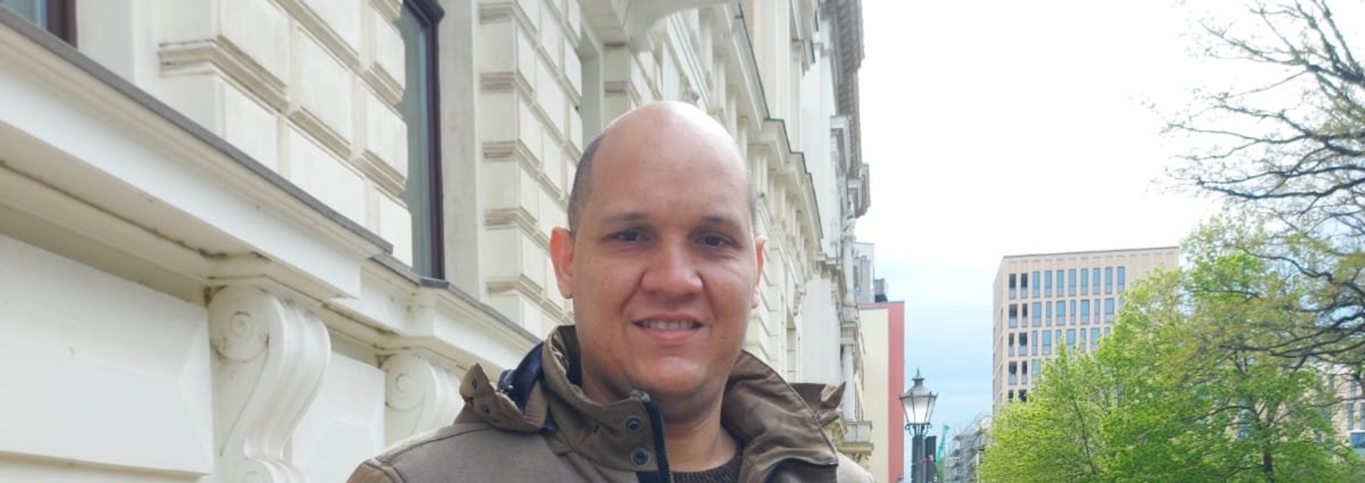 Ein großer, junger Mann steht auf der Straße.