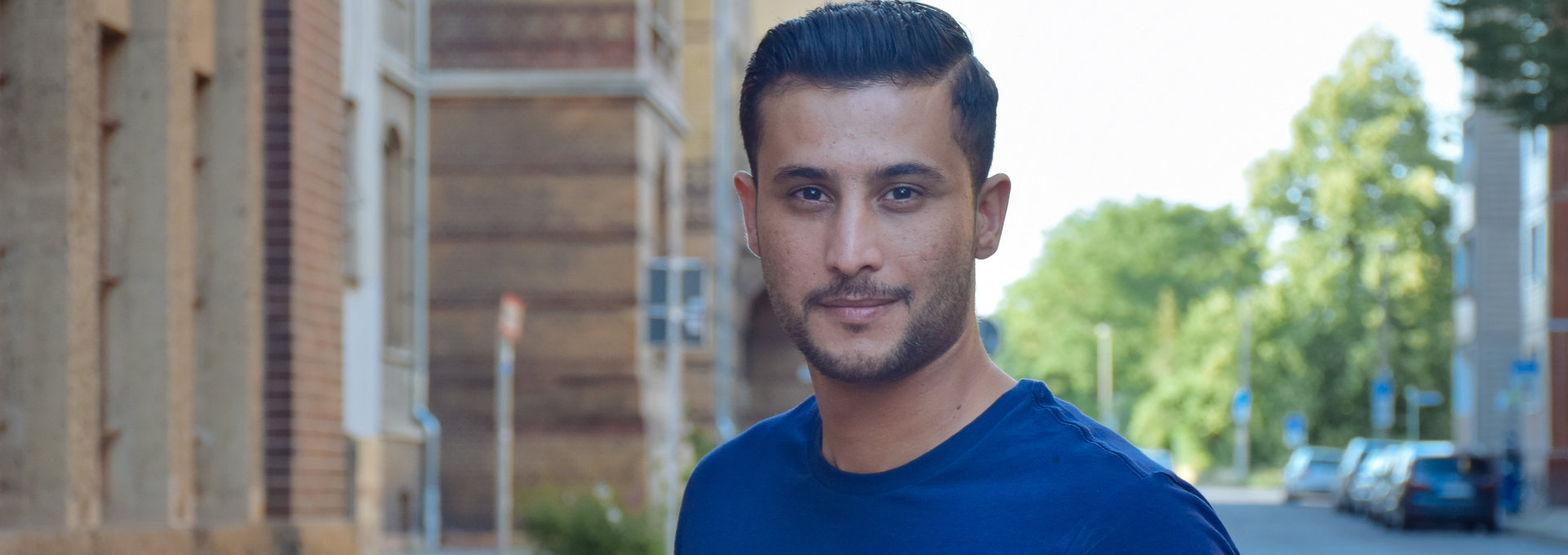 Ein junger Mann aus Syrien lächelt in die Kamera.