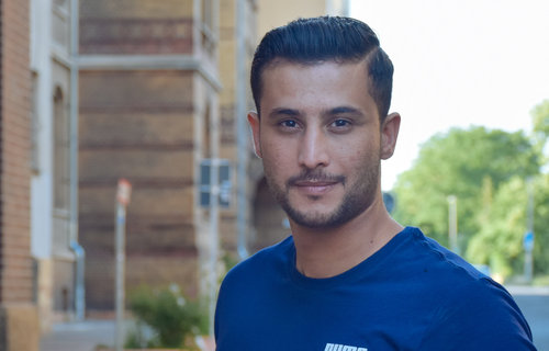 Ein junger Mann aus Syrien lächelt in die Kamera.