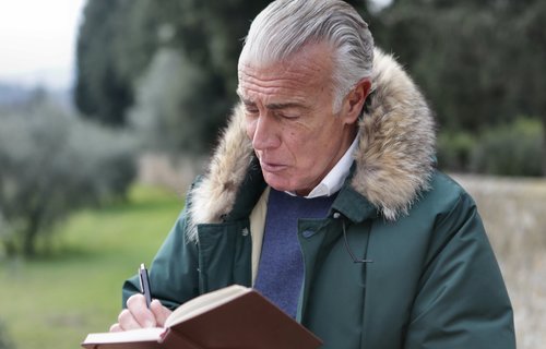 Ein älterer Mann liest in seinem Notizbuch