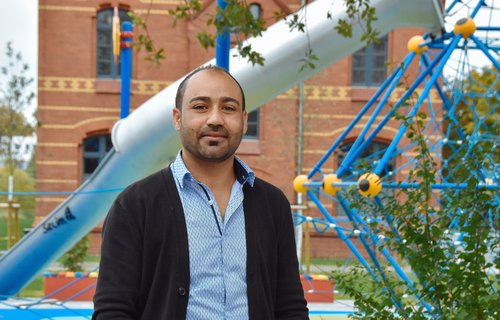 Ein junger Mann aus Syrien steht auf einem Spielplatz.
