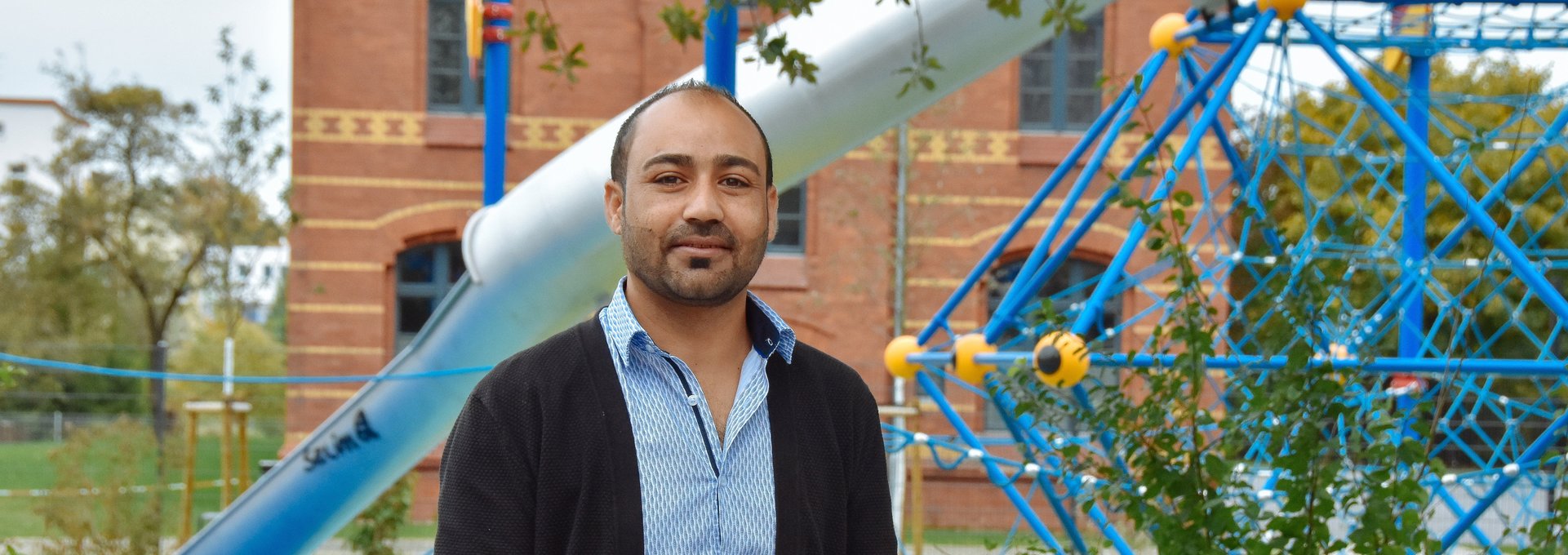 Ein junger Mann aus Syrien steht auf einem Spielplatz.