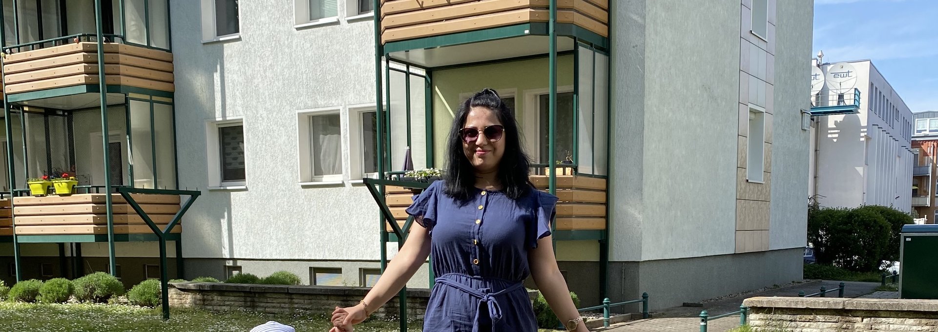Eine junge Frau steht vor einem Haus