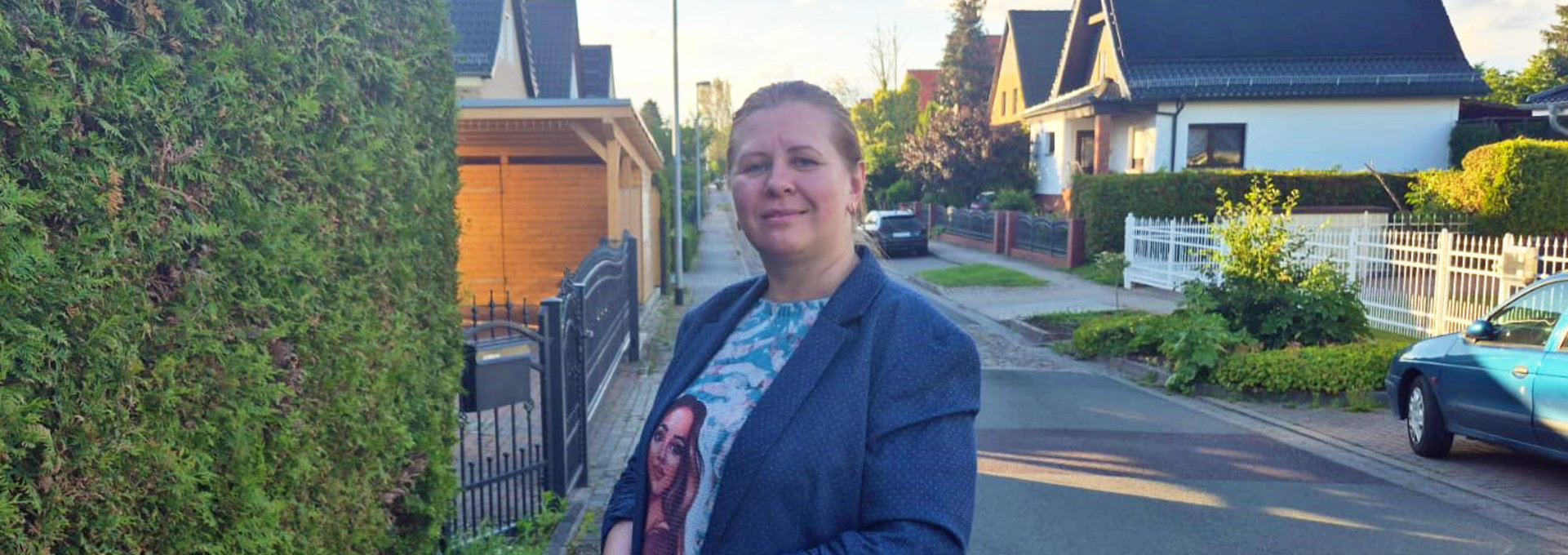 Eine Frau steht auf einer Straße im Wohngebiet