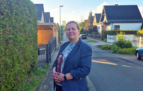 Eine Frau steht auf einer Straße im Wohngebiet